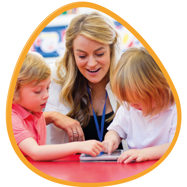An image showing two children on an iPad with their teacher.png